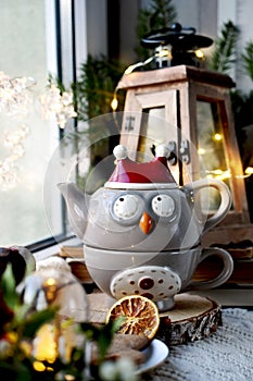 Owl shaped teapot and Christmas decors on window sill