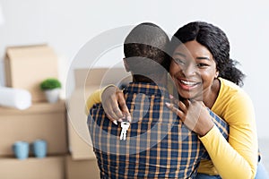 Own House. Happy Black Woman Holding Home Keys And Embracing Husband