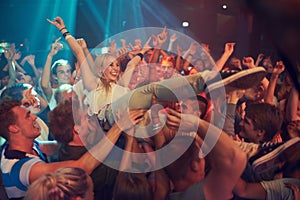 Own the night. Cropped shot of a woman crowd surfing at a music festival.