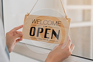 Owner business retail, asian young woman hand in turning sign board to open coffee shop, reopen store after close lockdown