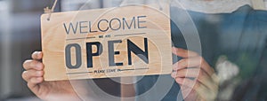 Owner business retail, asian young woman hand in turning sign board to open coffee shop, wearing face mask protect to pandemic of