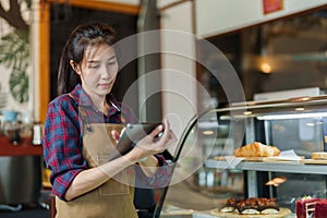 The owner is checking out the bakery. a tablet in hand Check orders according to customer orders whether the items are ready to