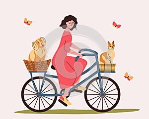 Owner with dog and cat on hike in nature. Pets sitting in bicycle basket. Girl travels with pets.