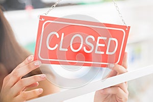 Owner Holding Closed Sign In Clothing Store