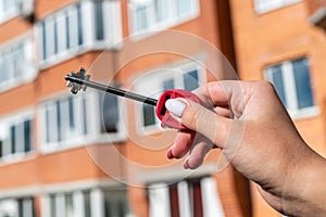 owner holds the key to the new house from the realtor.