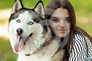 Owner and pet portrait. Teenage girl and her beloved dog. People hugs a husky