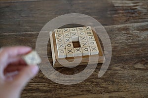 ox tic-tac-toe game made by wood block on wooden table. education & leisure concept. risk, strategy, competiton in business