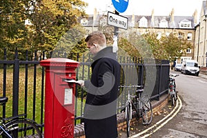 OXFORD/ UK- OCTOBER 26 2016: Man Posting Letter In Royal Mail Postbox