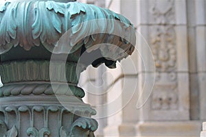 Oxidized classical column in front of limestone facade