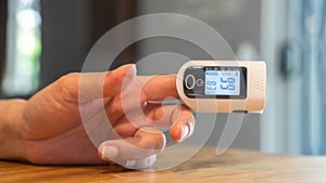Oximeter, pulse rate and blood oxegen level measurement on figertip of woman patient, medical equipment