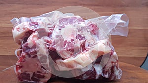 oxtail, raw, in vacuum plastic. on the table.