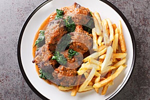 Oxtail in sauce Rabo de toro served with french fries on white plate on the concrete table. Horizontal top view