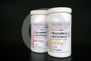 Oxycodone Hydrochloride prescription bottles isolated on black background.