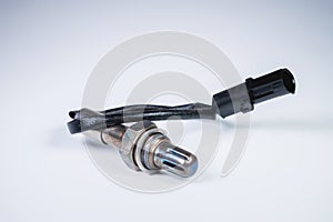 The oxygen sensor is a new lambda sensor. Spare parts on the car on a gray gradient background