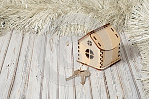 oy wooden house and two keys on a wooden table decorated for New Year or XMAS