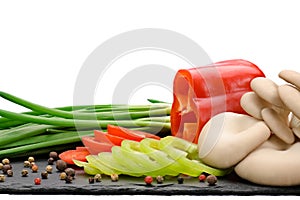 Oyster mushrooms and chopped vegetables with herbs and spices on a board made of natural slate