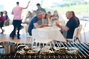 Oysters are cooked on the grill amid the visitors of the cafe