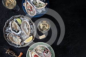 Oysters on ice, with various toppings and white wine, overhead flat lay shot
