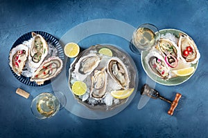 Oysters on ice, with various toppings and white wine, overhead flat lay shot