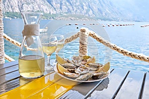 Oysters and white wine in a restaurant with a sea view