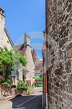 ÃÂ¡ozy cobblestone streets of medieval Carennac village, old houses with chimneys and tiled roofs. Lot, historical region of Quercy