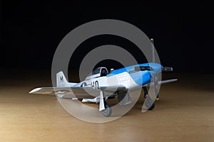 P-51 scale aircraft model over wood with black background