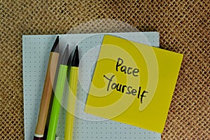 Pace Yourself write on sticky notes isolated on Wooden Table