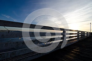 Pacific beach boardwalk fence highlighted by sunset