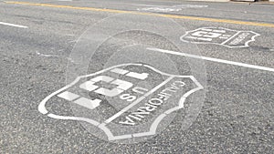 Pacific Coast Highway road marking on asphalt, historic route 101 sign in California, trip in USA.