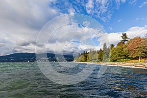 Pacific coastline seawall pathway and fresh green garden of Stanley park with blue sky in summer sunset at Vancouver of British