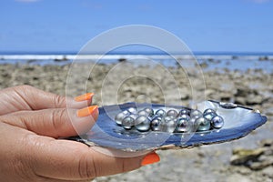 Pacific Islander woman holds Tahitian Black Pearls