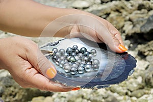 Pacific Islander woman holds Tahitian Black Pearls