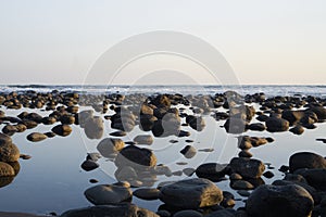 Pacific Ocean coast in El Salvador. Reflection of rocks or stones in the water