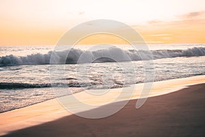 Pacific waves and sandy beach at sunset