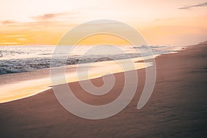 Pacific waves and sandy beach at sunset