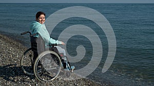 Pacified caucasian woman in a wheelchair on the seashore. photo