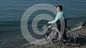 Pacified caucasian woman in a wheelchair on the seashore. photo