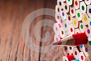 Pack of color pencils with a single sharp one symbolizing leadership concept