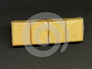 A pack of cookies or crackers in cellophane packaging .  Selective focus
