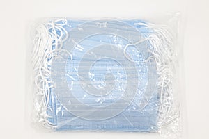 Pack of disposable blue new medical masks isolated on white background