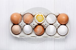 Pack of farm chicken eggs in cardboard container on white