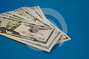 Pack of fifty dollars banknotes isolated on blue background