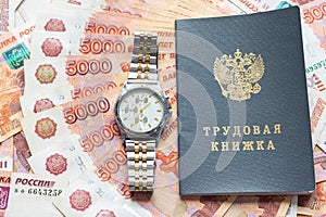 On a pack of five thousandth bills there is a work book and a watch