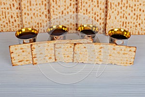 Pack of matzah or matza, Passover Haggadah and Kosher red wine on a vintage wood background