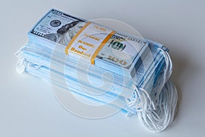 A pack of medical masks and a stack of 100 dollars bills as a symbol of higher prices and a deficiency in the protection of the