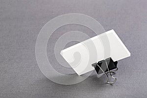 Pack of paper blanks for business cards with a metal clip on a light background