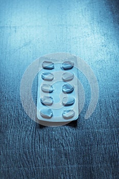 pack of pills on a blue retro table