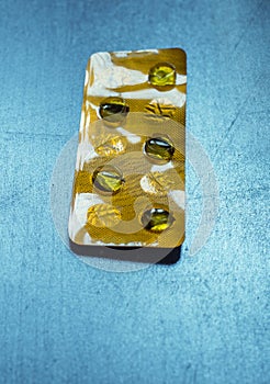 pack of pills on a blue retro table