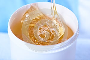A pack of stretchy golden luminous sugaring paste, close-up photo