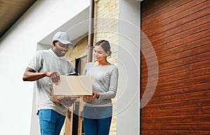 Package Delivery. Man Courier Delivering Box To Woman At Home